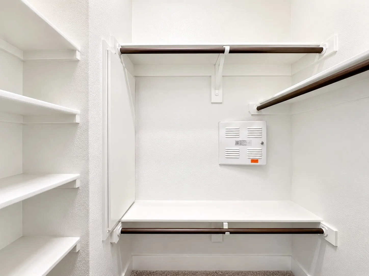 Built-in shelving, multiple hanging rods, corner shelf, and textured wall finish