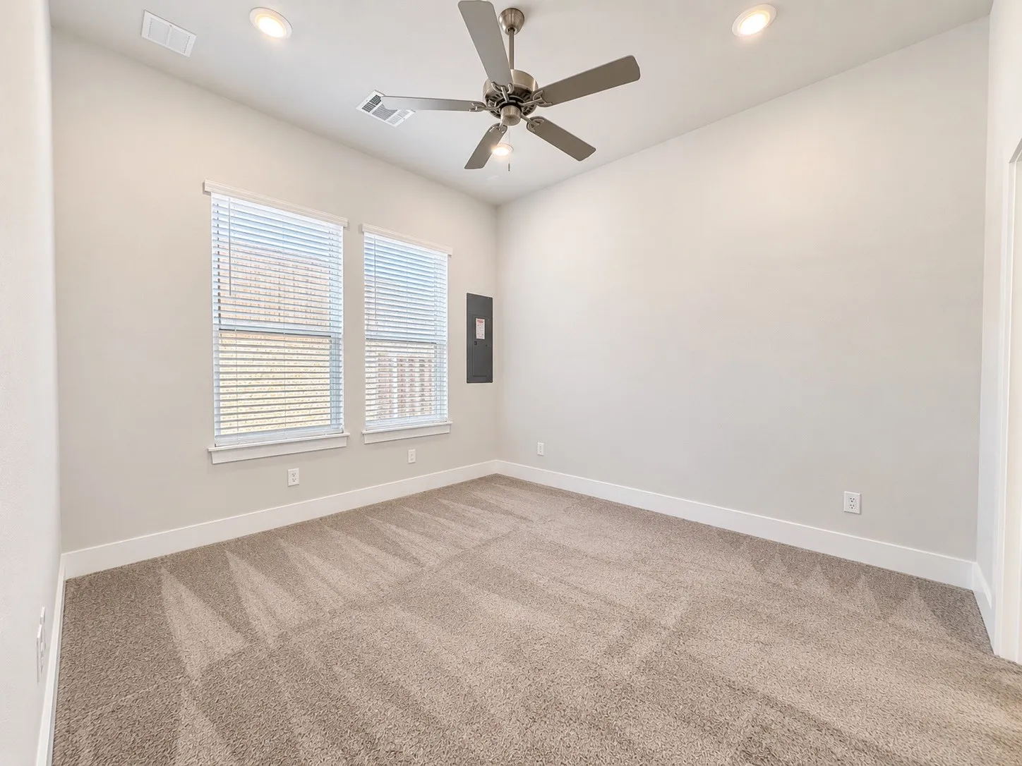 Recessed lighting, ceiling fan, neutral wall paint, carpet flooring, and dual windows with blinds