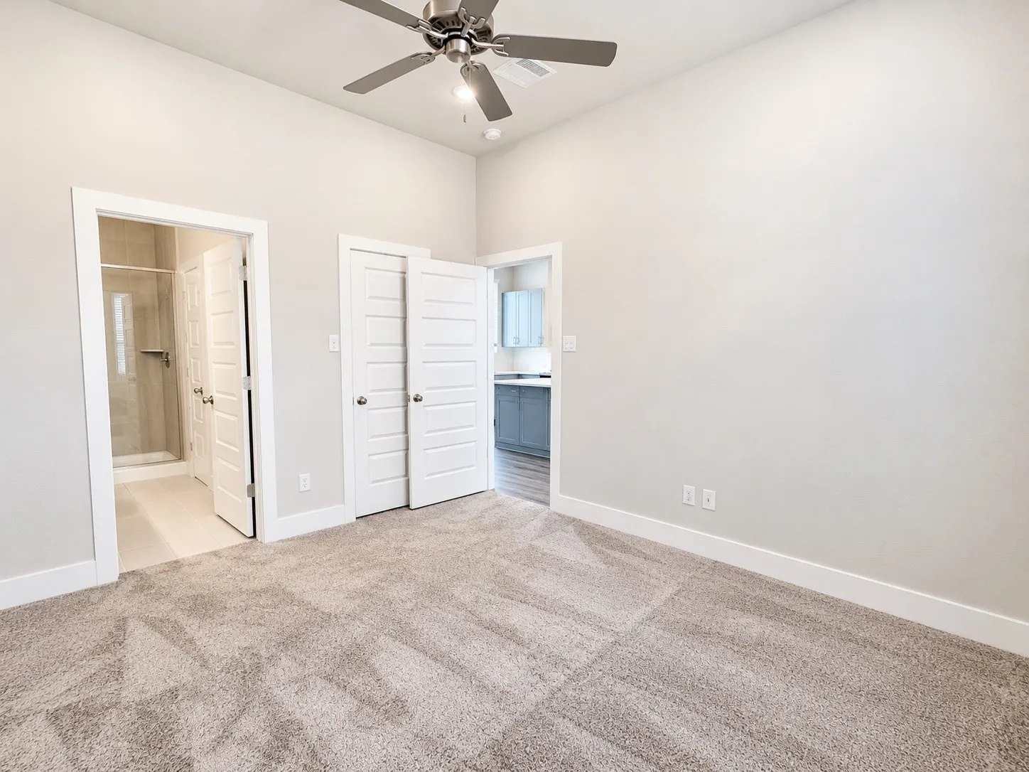 Vaulted ceiling with a ceiling fan, carpeted flooring, and white trim