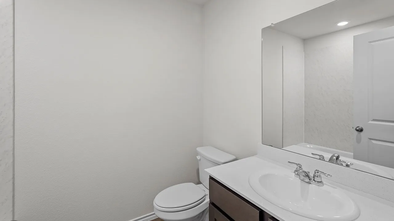 Recessed lighting illuminating the vanity with an integrated sink and chrome hardware