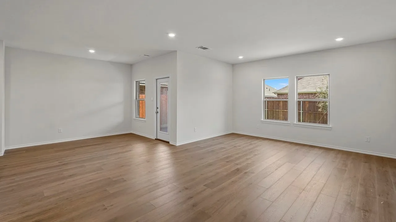 Expansive room featuring wood-finish flooring, recessed lighting, and multiple windows for abundant natural light