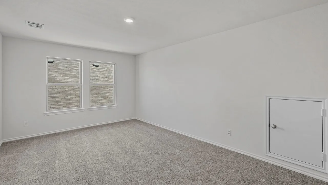 Carpeted room with two windows, white walls, and a built-in access panel