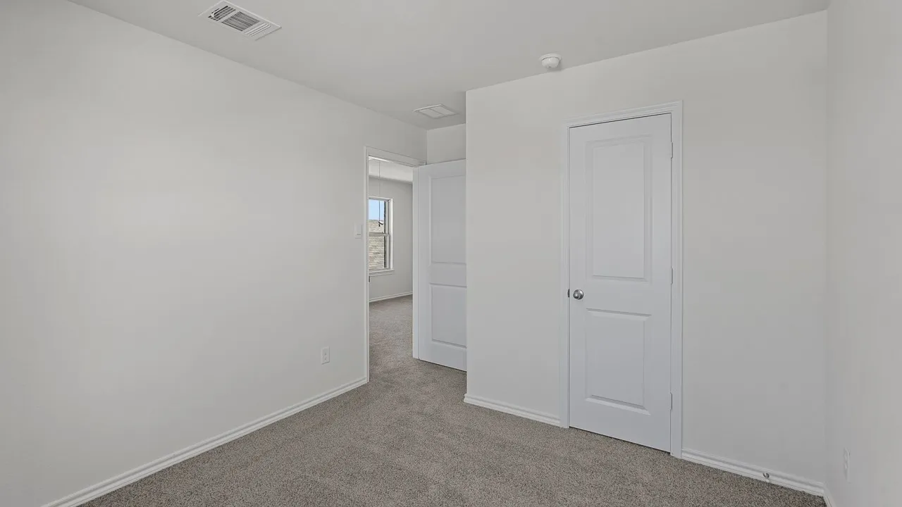 Carpeted room with white walls, white trim, and white two-panel doors