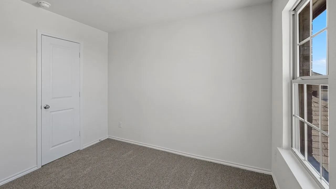 Light gray wall paint, gray carpet, and a white two-panel interior door