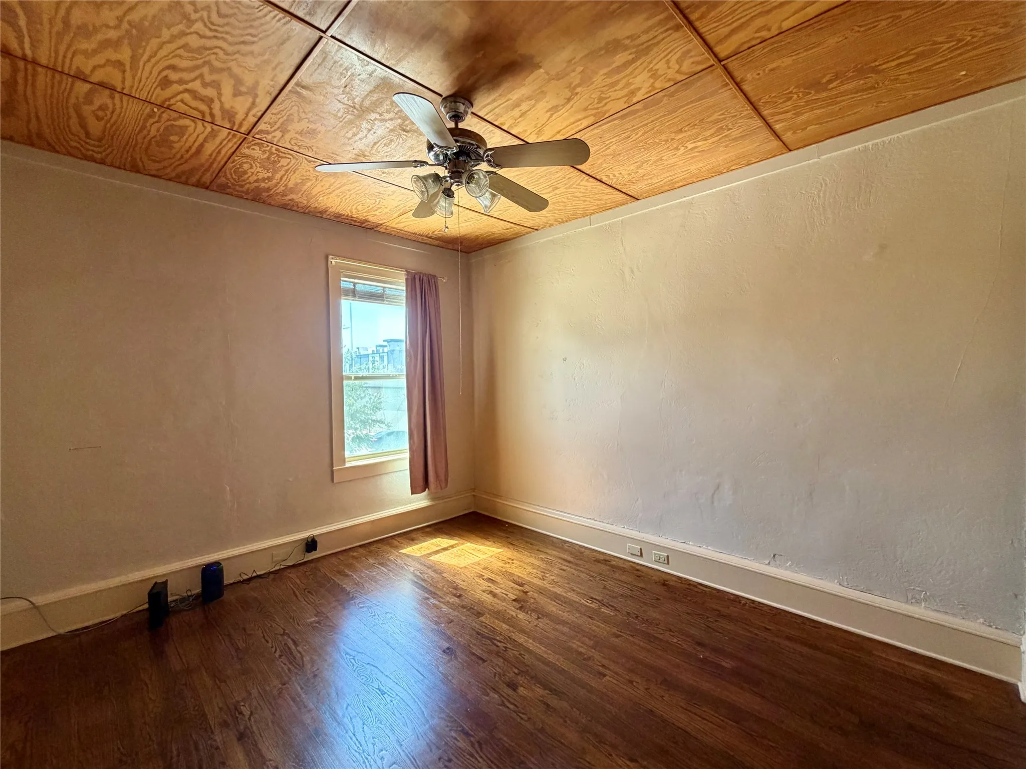 Hardwood flooring with a wood-paneled ceiling and ceiling fan