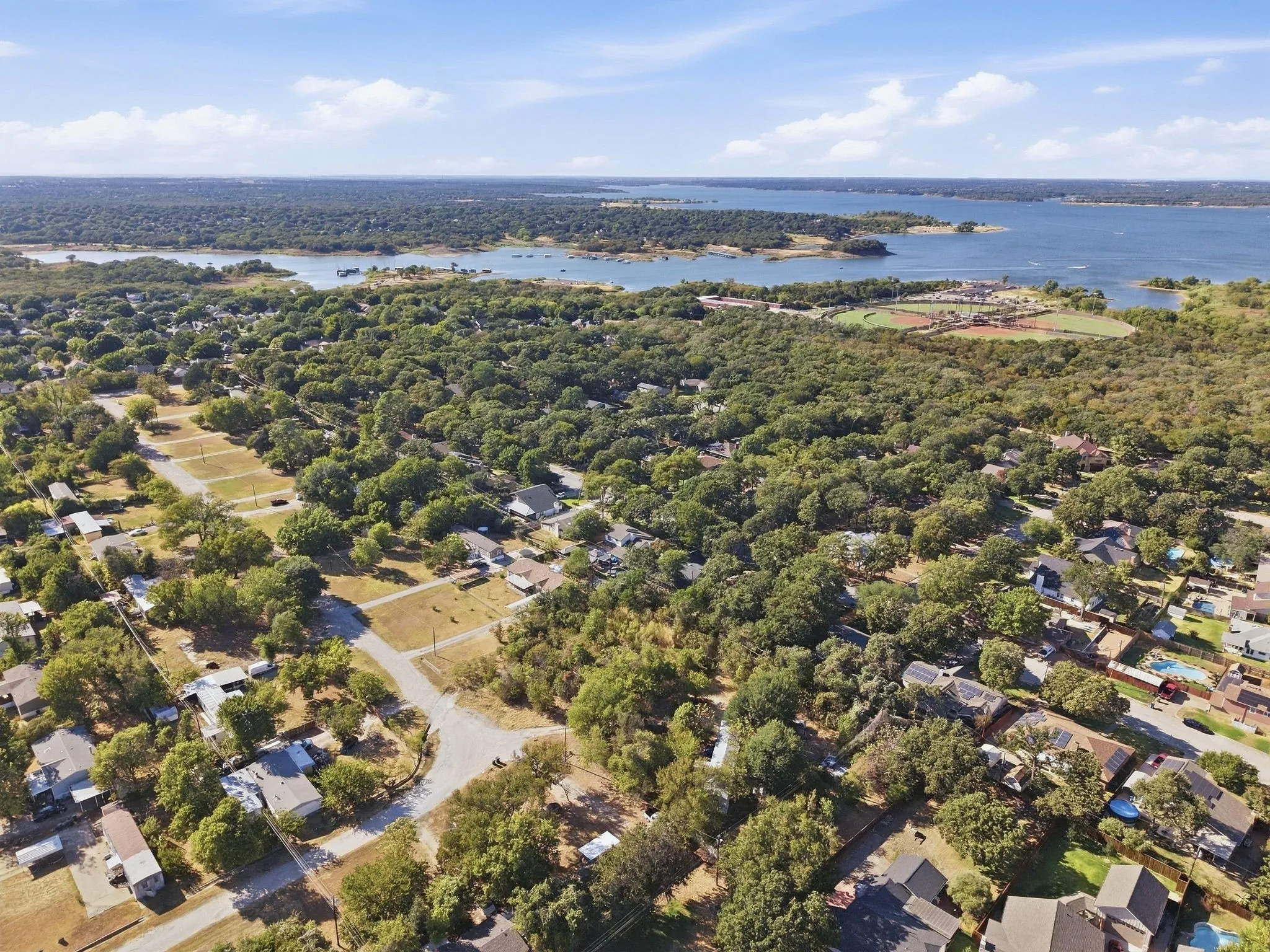 Aerial perspective of Grapevine Lake, extensive tree canopy, and neighborhoods