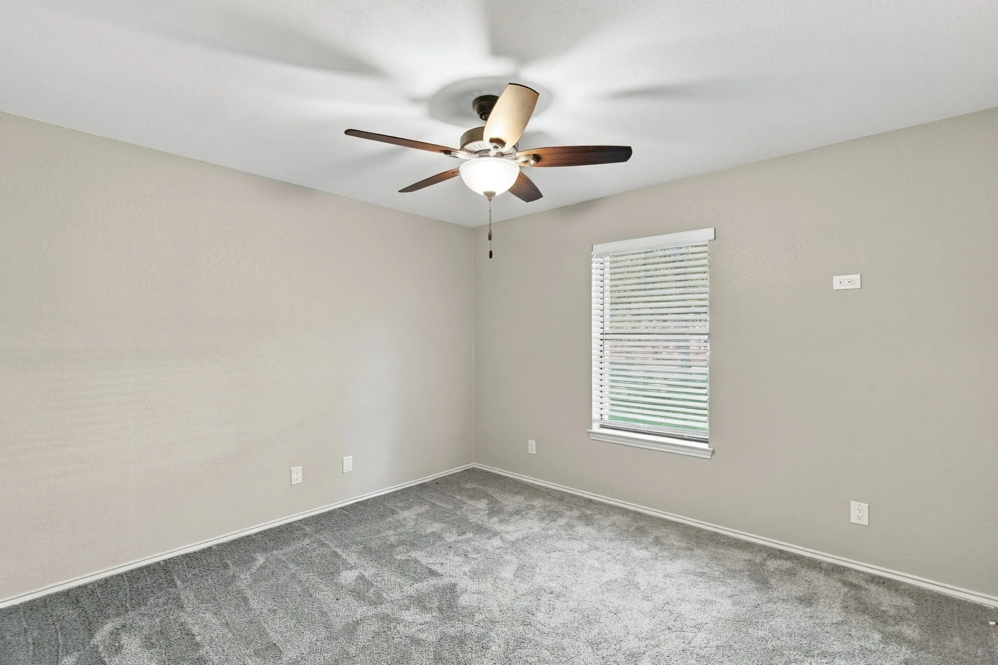 Spacious room with ceiling fan with light, and neutral wall paint