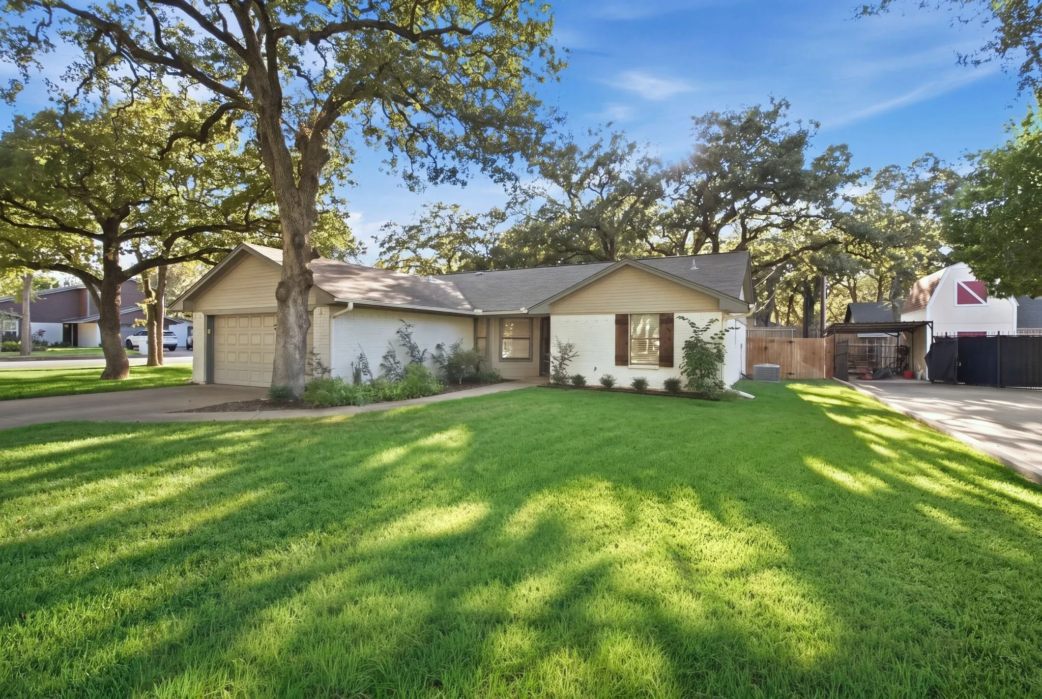 Single-story residence featuring a two-car garage, established front landscaping, and a substantial driveway
