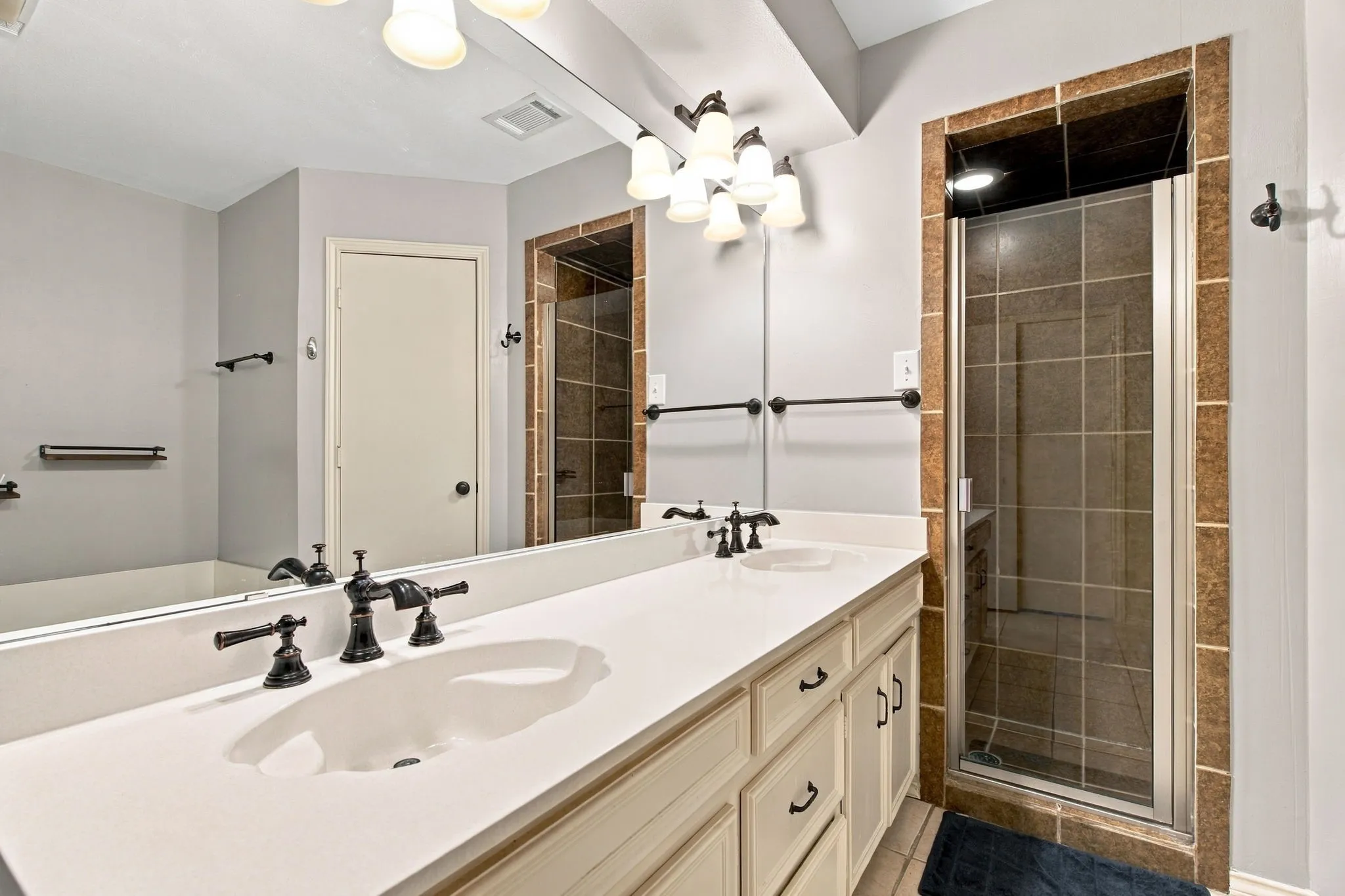 Double vanity with integrated sinks, oil-rubbed bronze fixtures, and lower cabinetry