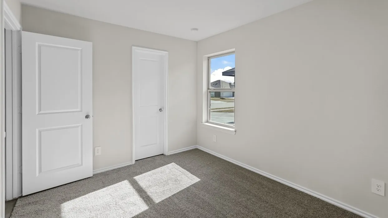 Light gray wall finish, white trim, gray carpet flooring, white paneled doors, and a double-hung window