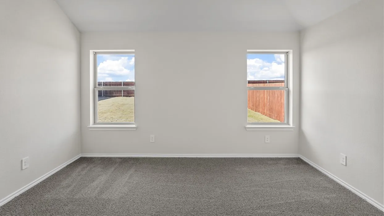 Neutral wall color, grey carpeting, and two windows with white trim