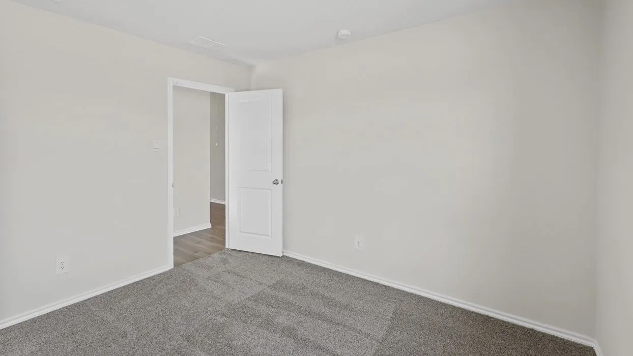 Neutral paint palette, gray carpeting, white trim, and a white interior door