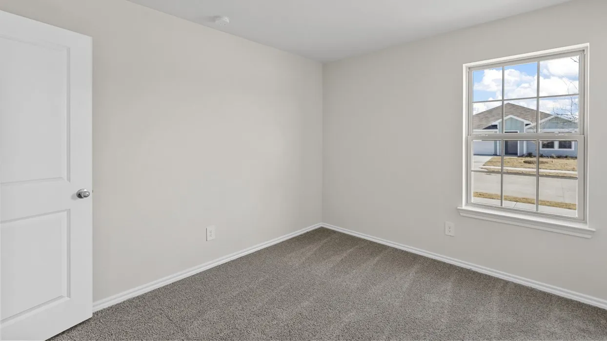 Neutral wall paint, white trim, paneled interior door, window with grid, and gray carpet