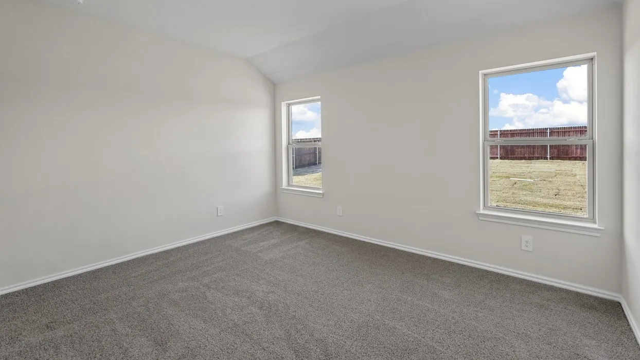 Carpeted room featuring white walls, vaulted ceiling, and dual windows
