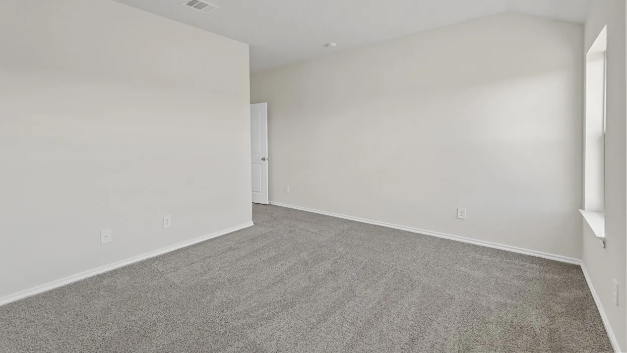 Neutral wall finishes, textured carpeting, vaulted ceiling, and a prominent window