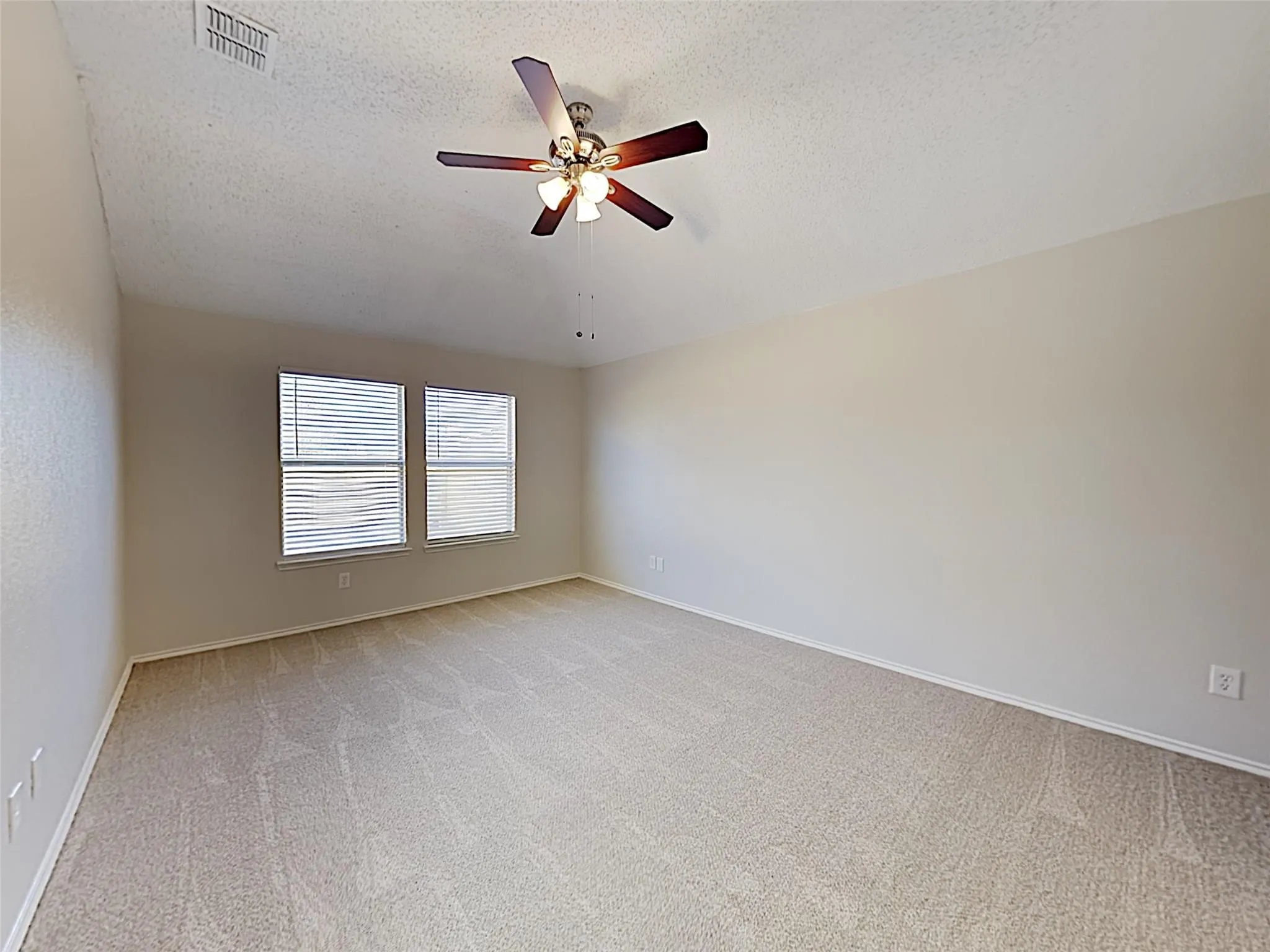 Wall-to-wall carpeting, two large windows with blinds, and a ceiling fan with integrated lighting
