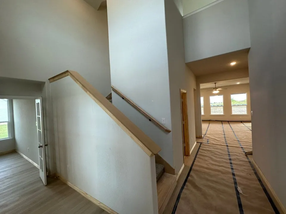 Two-story entryway with high ceilings and wood-finish handrails