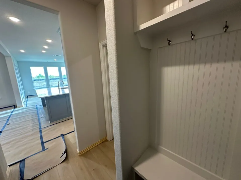 Built-in mudroom bench with beadboard paneling and storage hooks