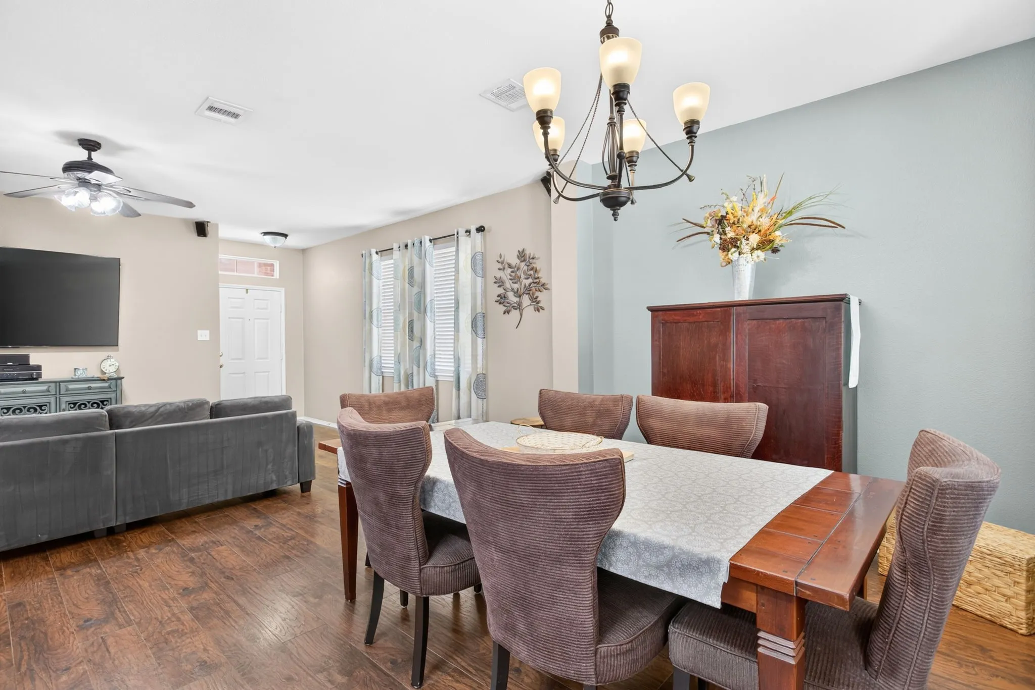 Wood-finish flooring throughout, modern ceiling fan, recessed lighting, and a decorative chandelier