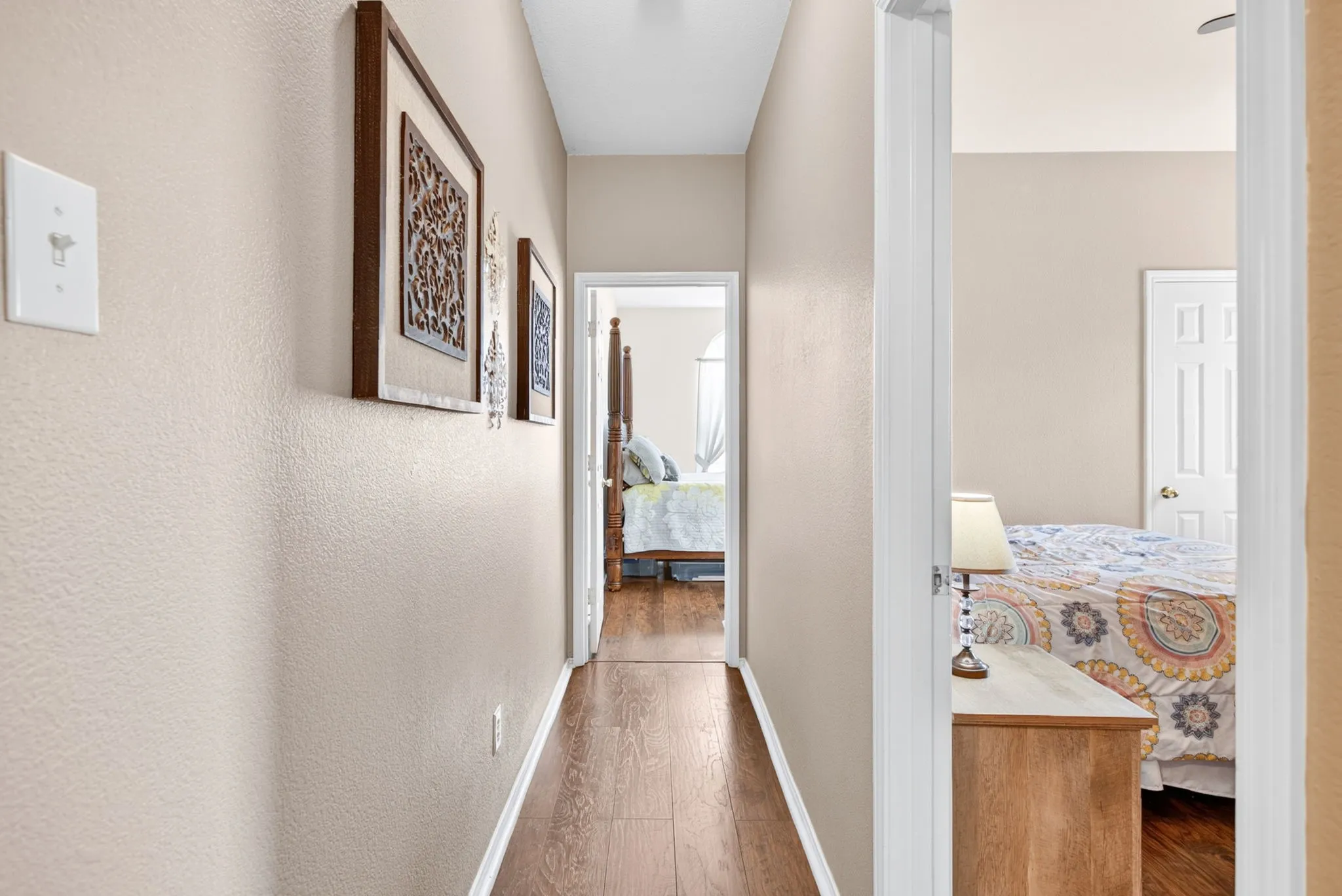 Hallway featuring wood-finish flooring and neutral wall tones