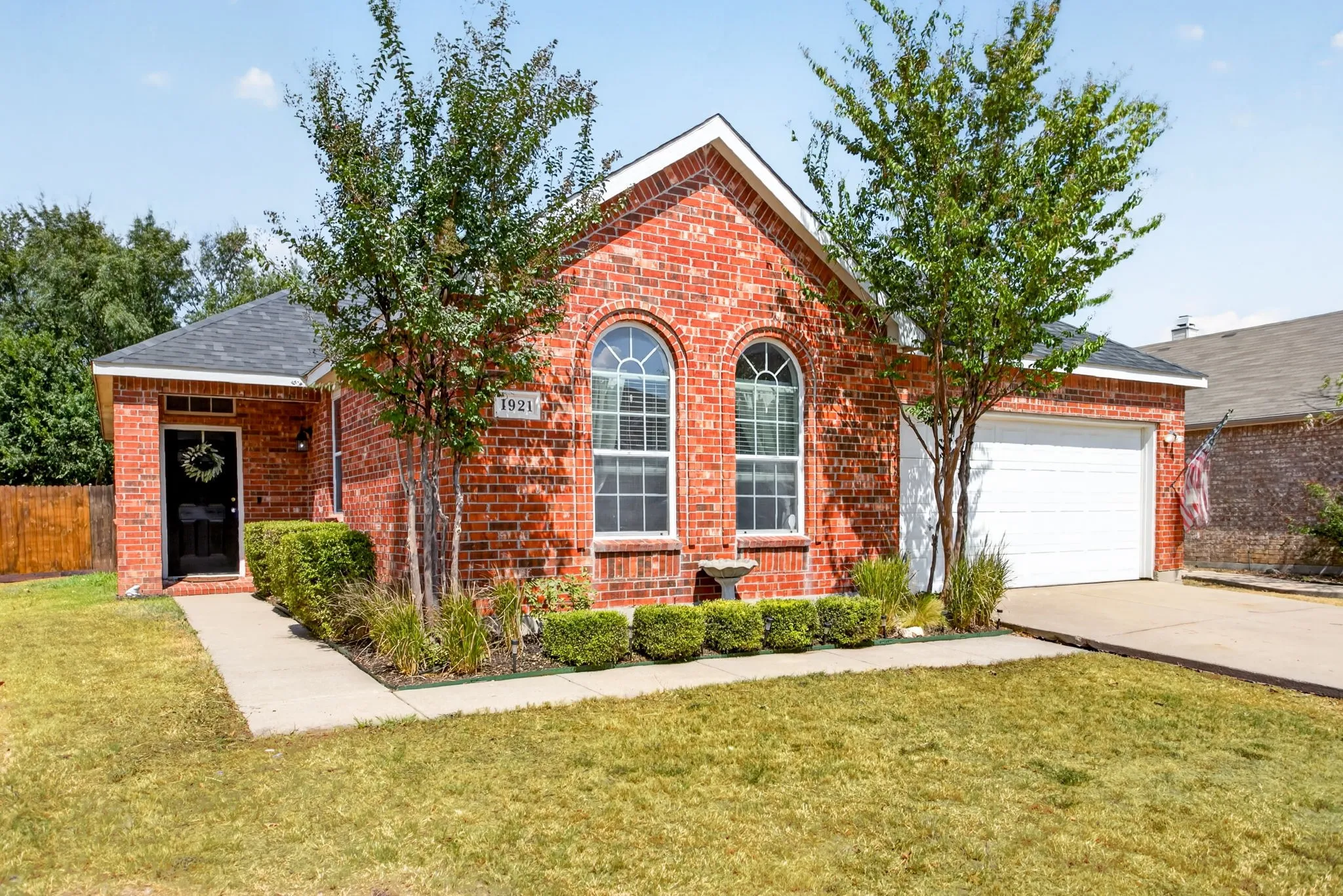 Red brick exterior with a dark roof and a two-car garage