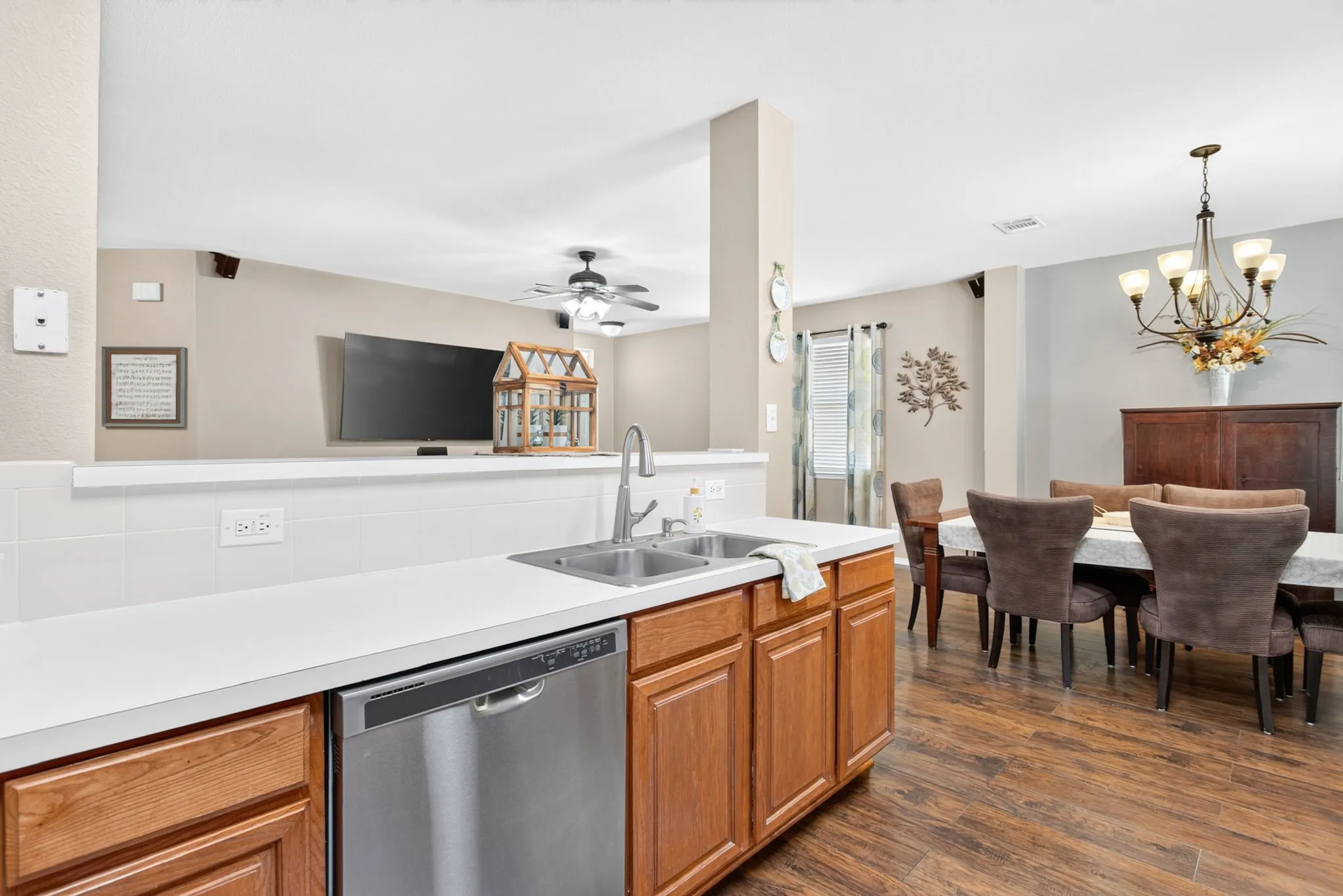 Kitchen featuring a stainless steel sink with a high-arch faucet, a stainless steel dishwasher, and wood-finish cabinetry