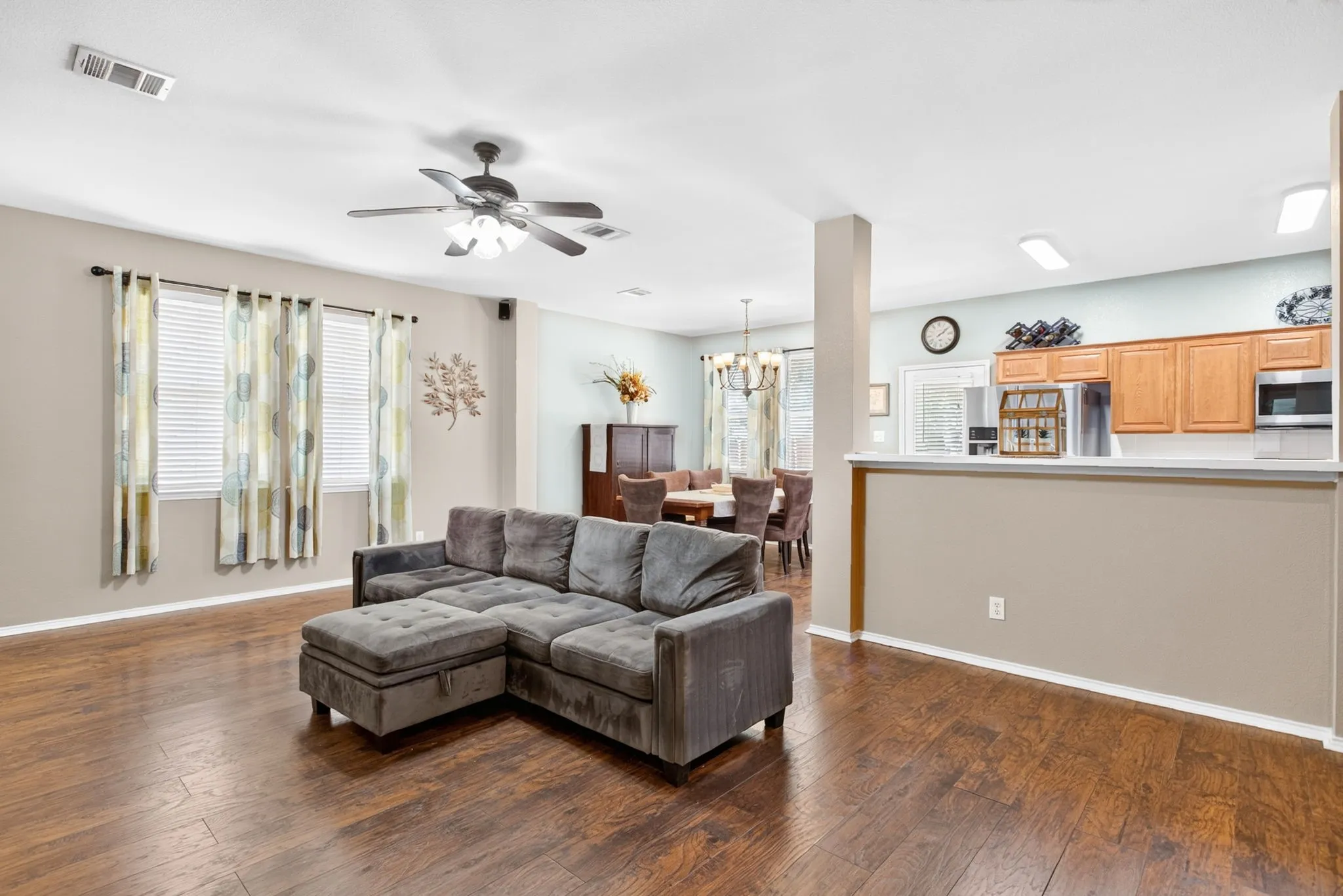 Open-concept living area featuring wood-finish flooring, recessed lighting, and ceiling fan