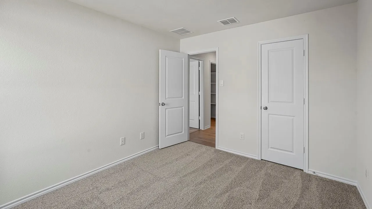 Neutral-toned carpeting, white walls, and white trim