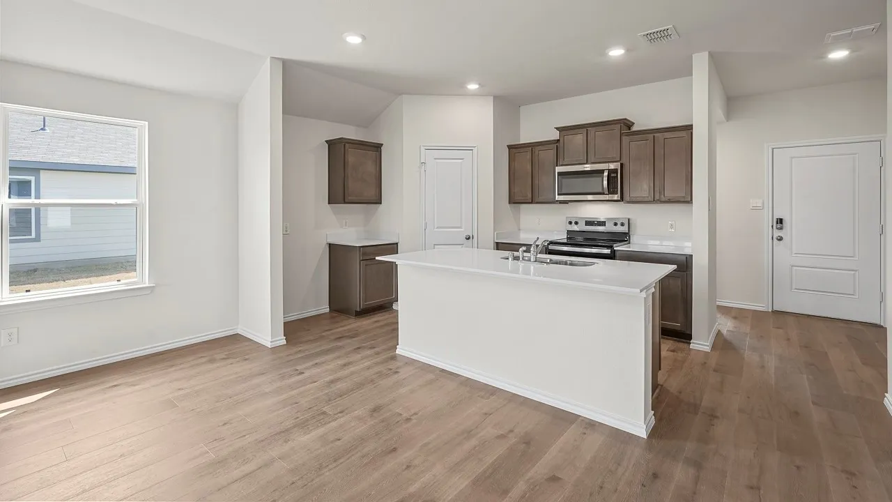 Open-concept living space with wood-finish flooring, recessed lighting, and vaulted ceilings