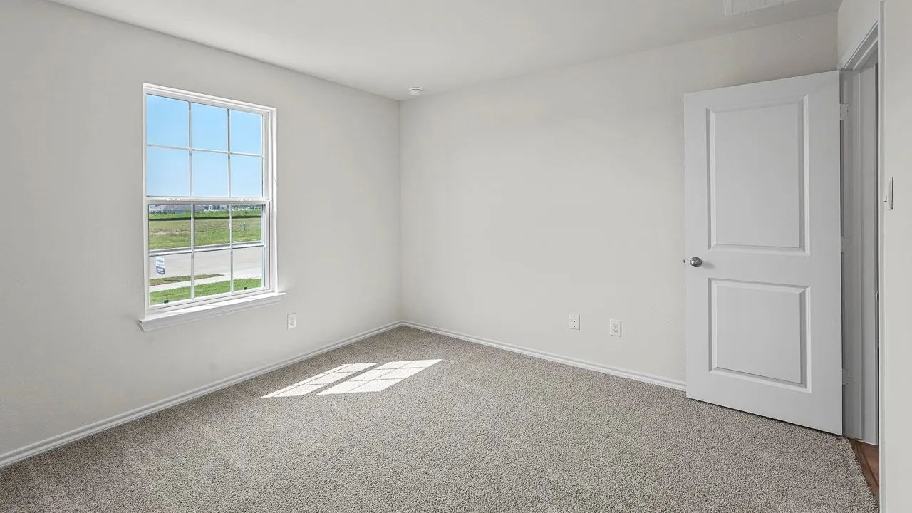 Grey carpet flooring, white painted walls, window with gridded panes, white paneled door, and ceiling-mounted light fixture