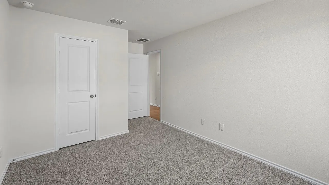 Neutral toned walls with textured finish, gray carpet flooring, and white interior doors