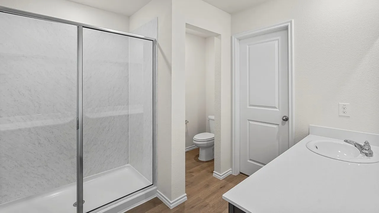 Walk-in shower with clear glass enclosure and white surround