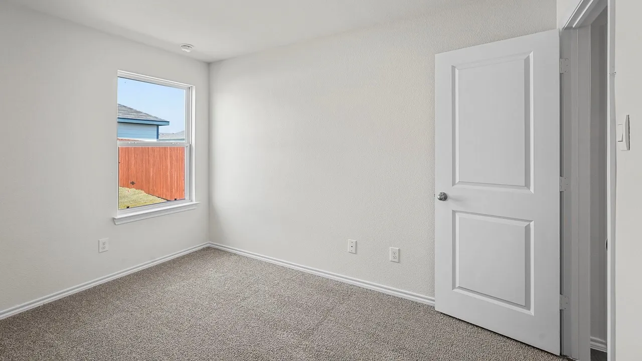 Neutral-toned walls, gray carpet flooring, white trim, and a panel door with a satin nickel knob