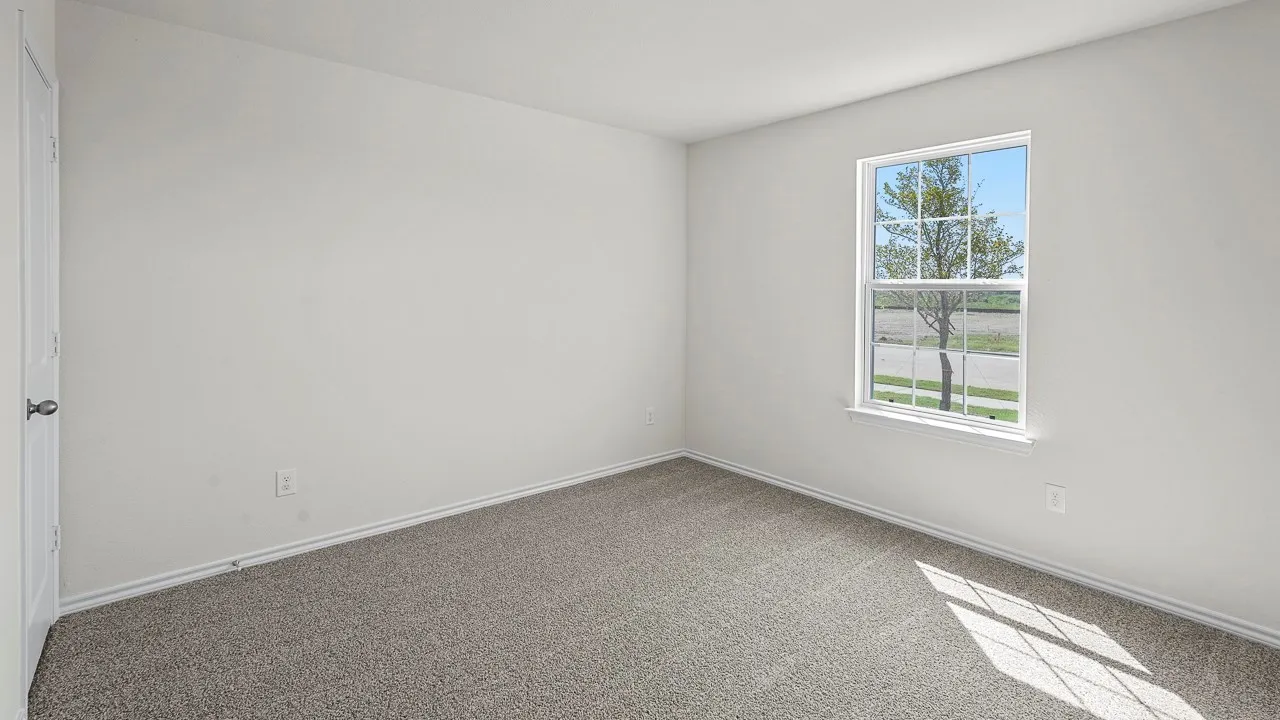 Carpeted flooring, white painted walls, single window with grid pattern, white trim