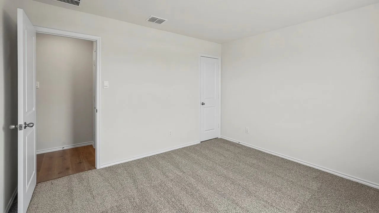 Neutral wall paint, carpet flooring, a single paneled door, and a built-in closet