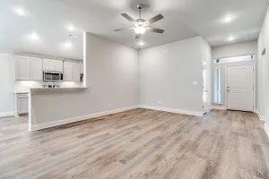 Wood-finish flooring, recessed lighting, and a ceiling fan in the living area