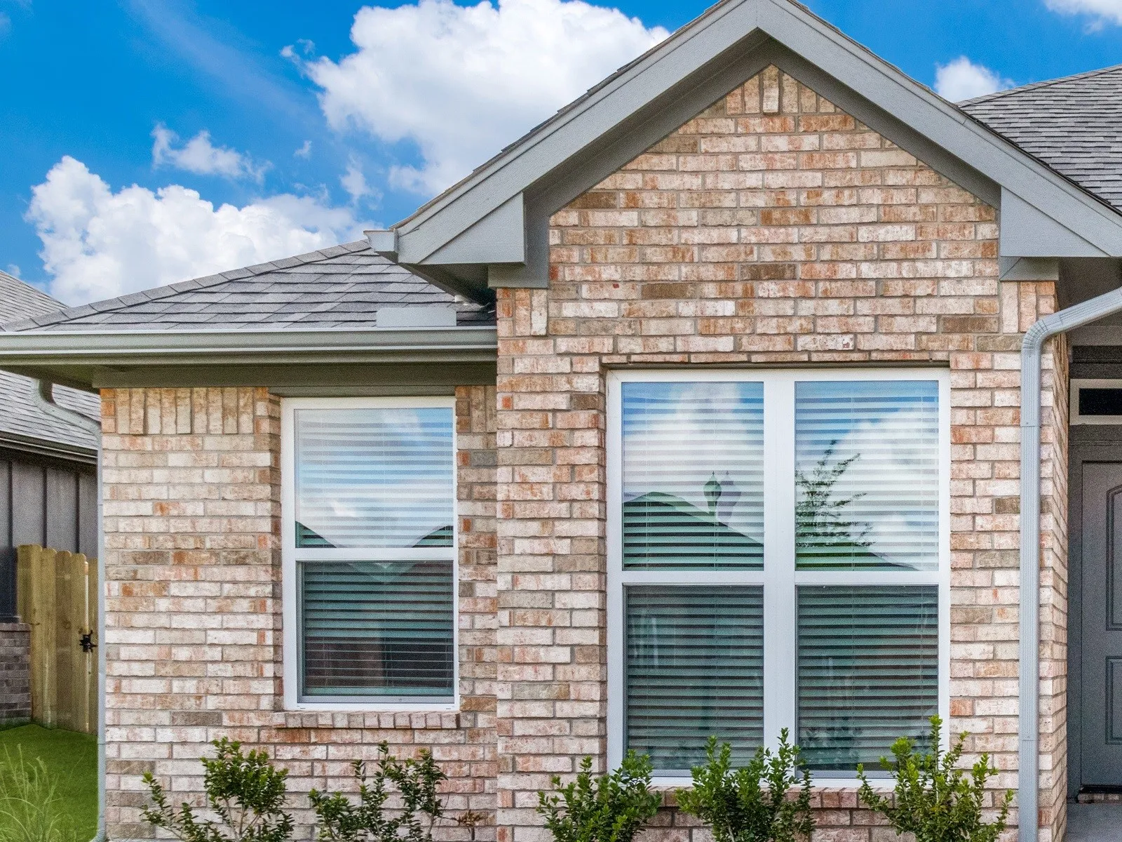 Brick veneer exterior with a gabled roofline and gray shingles