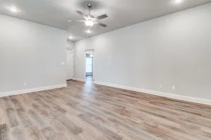 Wood-finish flooring throughout, complemented by a ceiling fan with integrated lighting