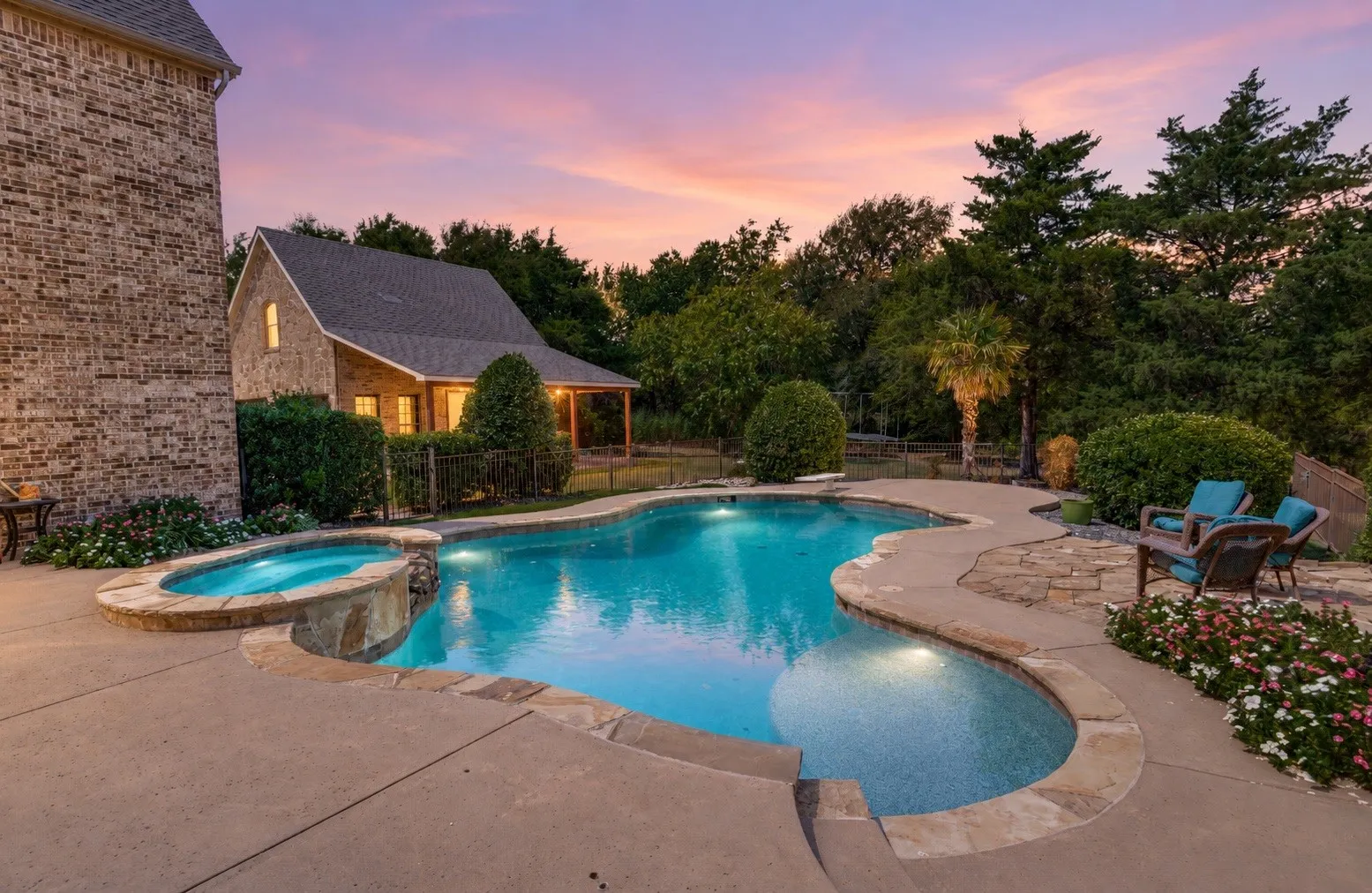 Freeform swimming pool with integrated spa and stone coping