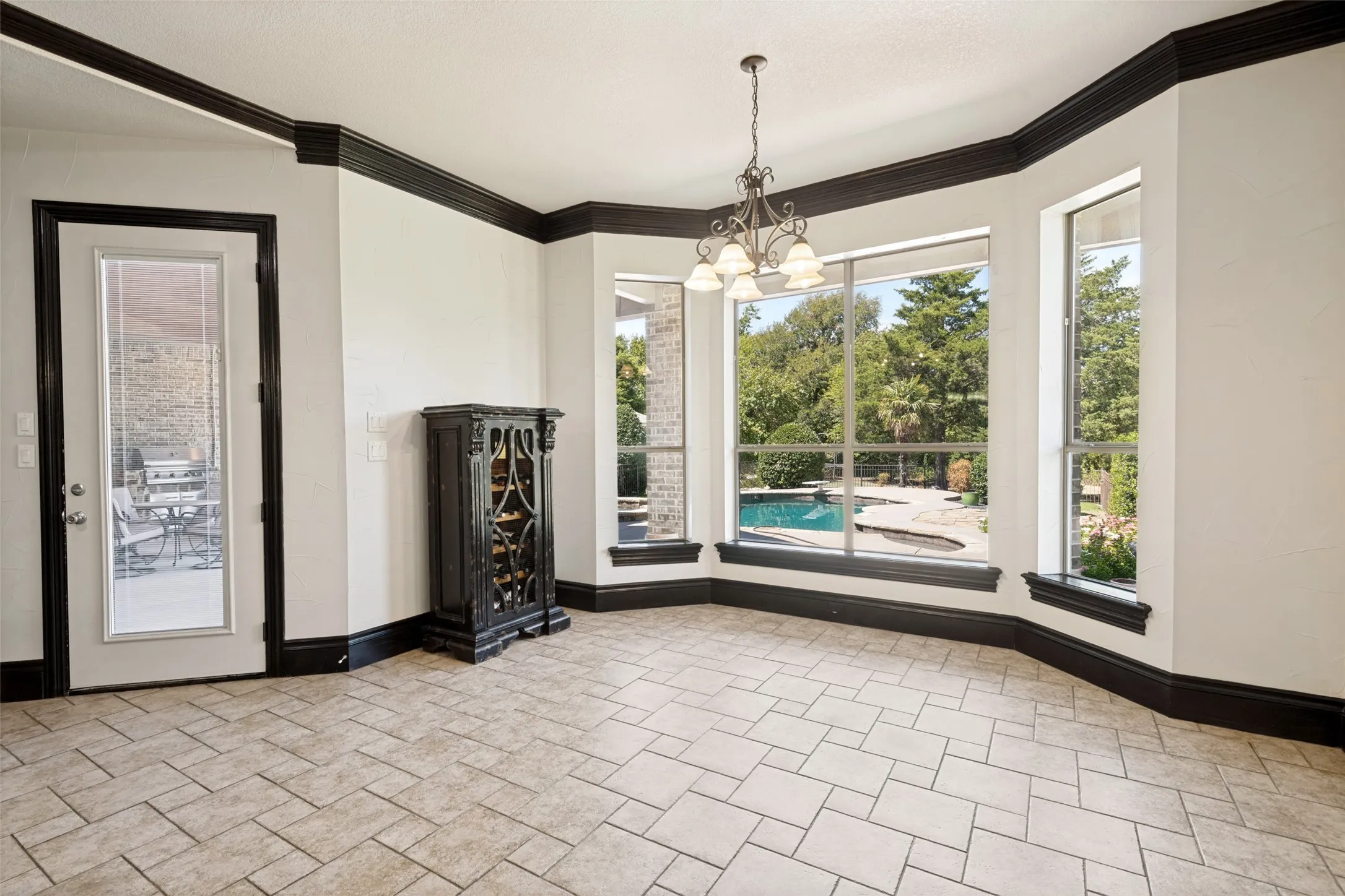 Tile flooring, dark trim accents, multiple large windows, and a built-in light fixture