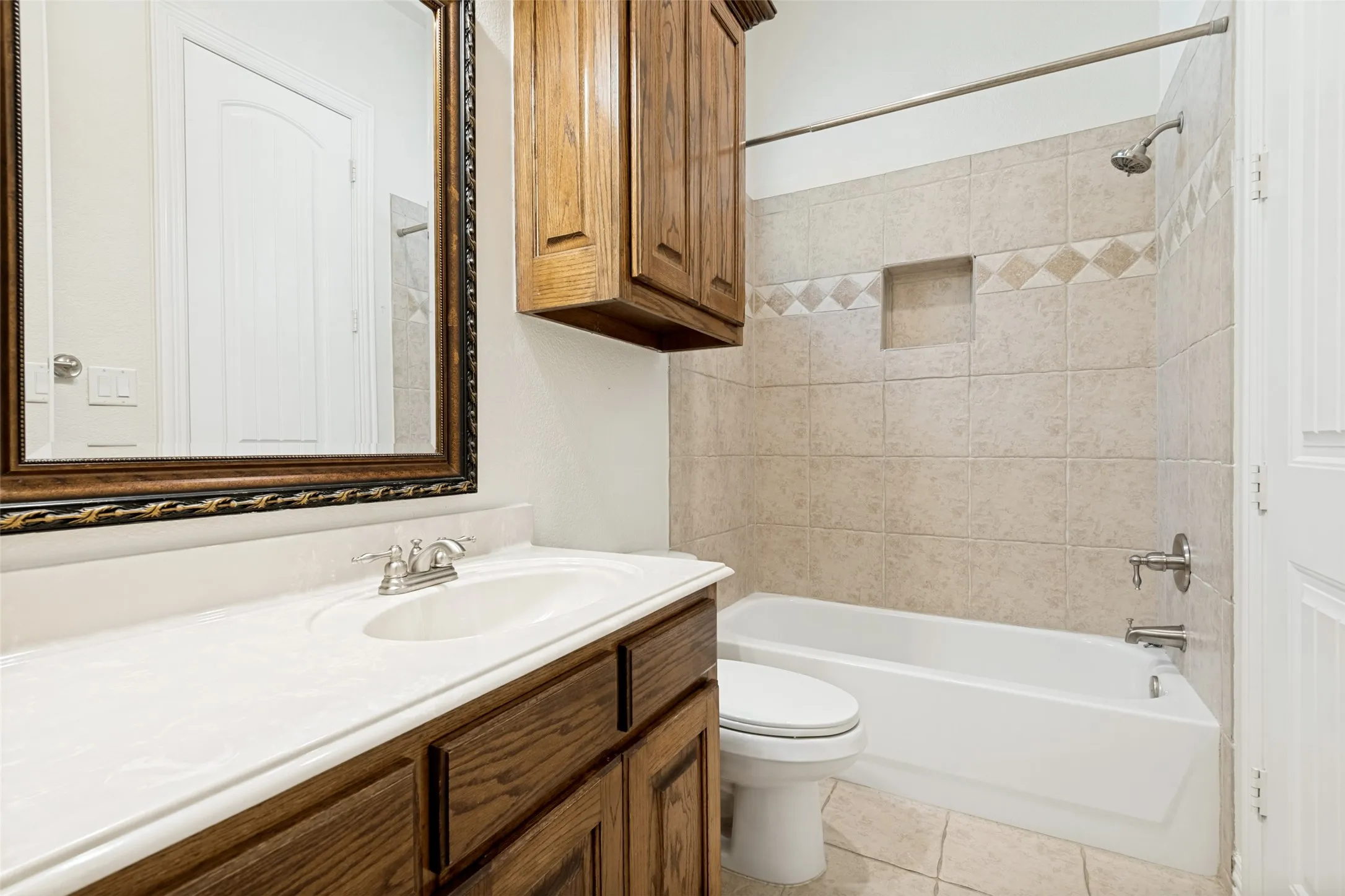 Bathroom featuring a vanity with wood-finish cabinetry, a white countertop, and a built-in sink