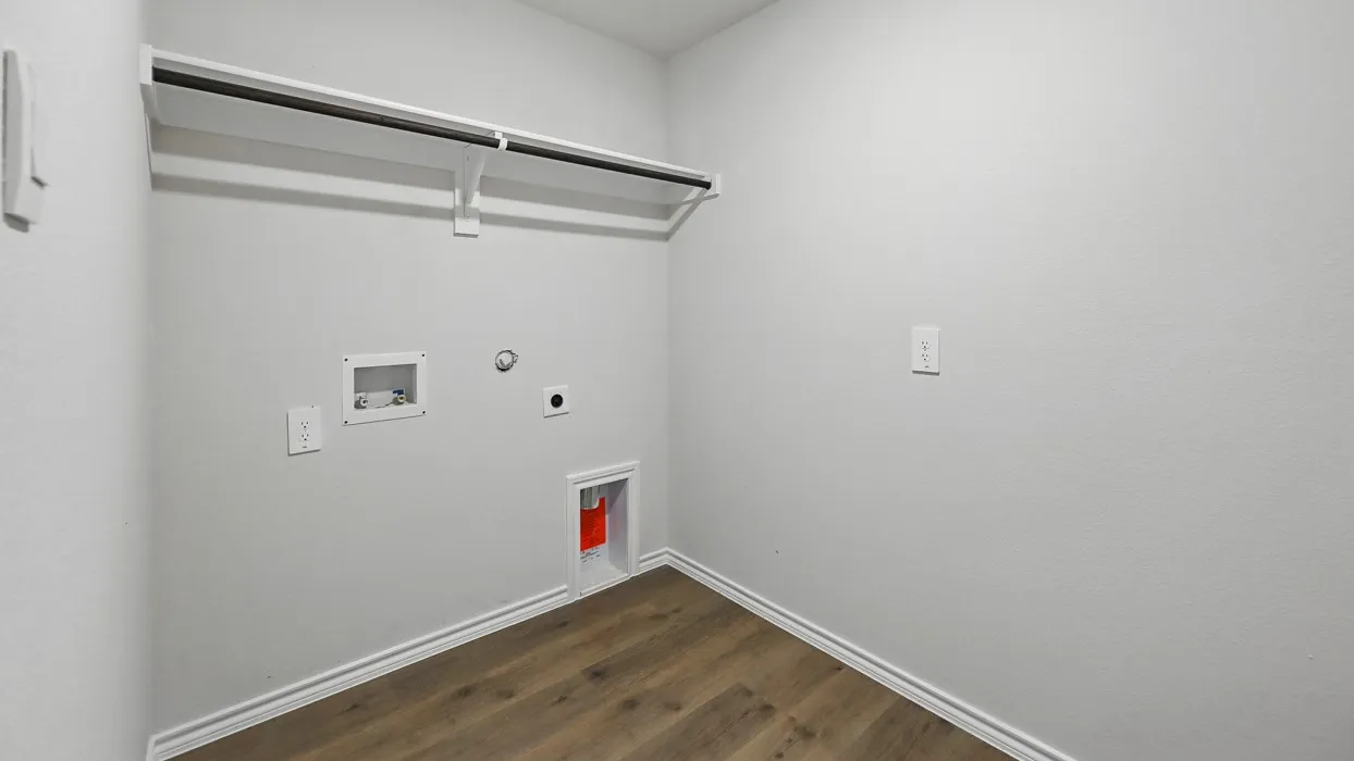 Laundry area featuring wood-finish flooring, a clothing rod, and essential appliance hookups