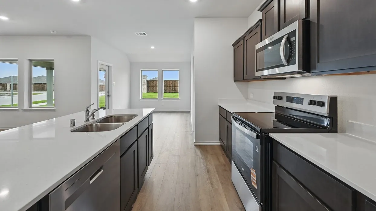 Kitchen featuring dark wood-finish cabinetry, stainless steel appliances, white countertops, and wood-finish flooring