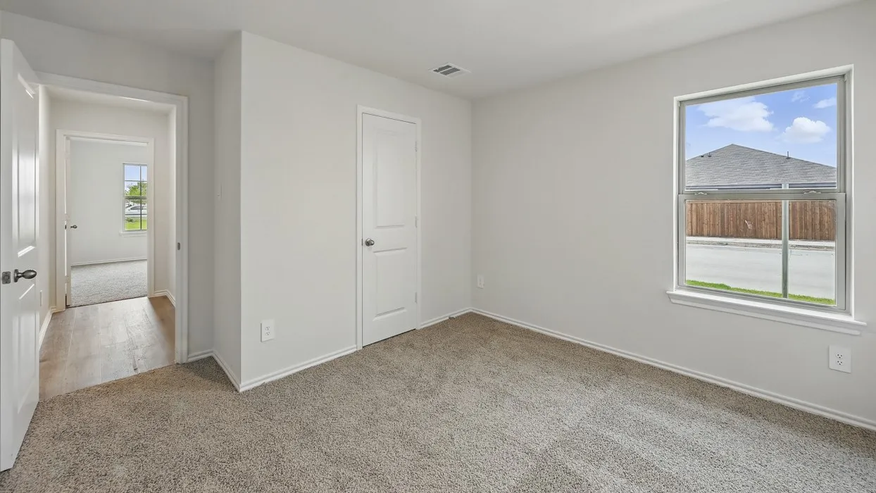 Neutral wall color, carpeted flooring, white trim, white interior doors, and a double-pane window
