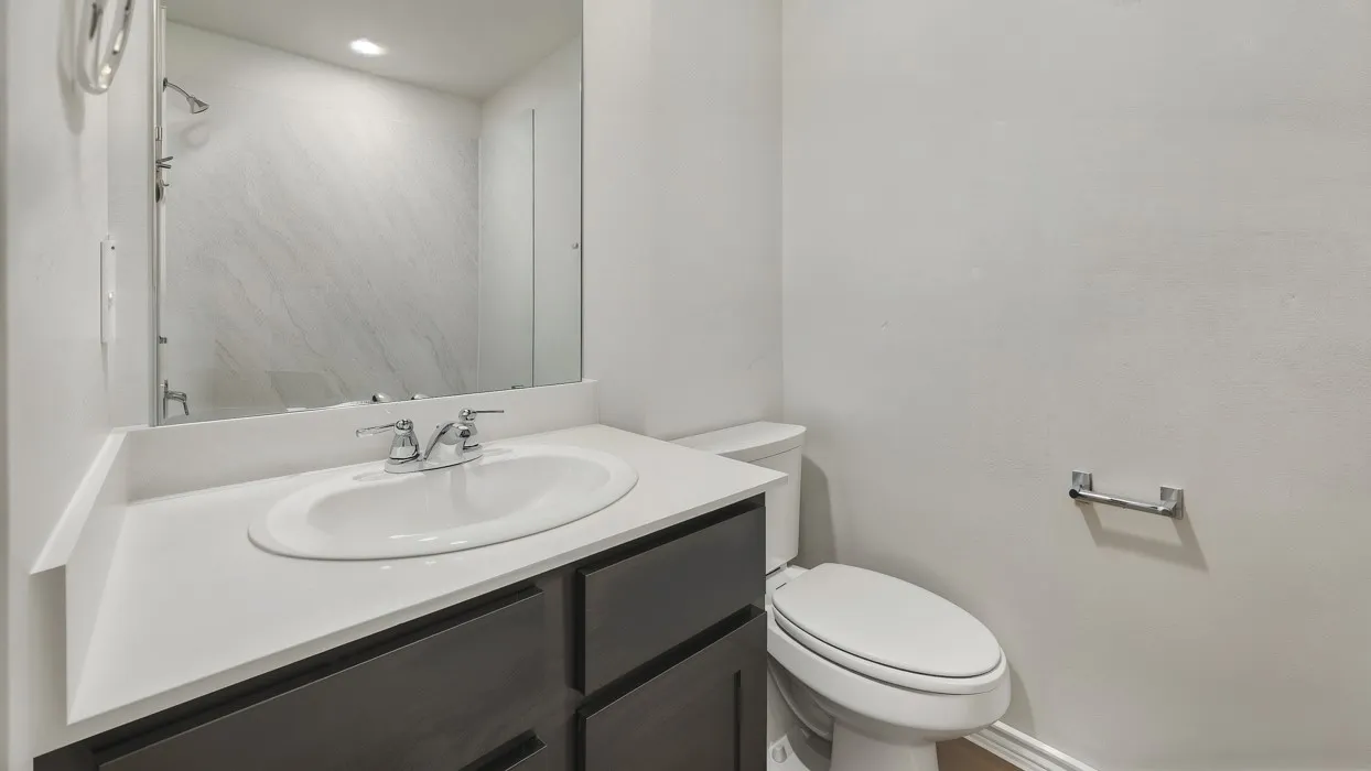 Vanity with white countertop and integrated sink, dark wood-finish cabinetry, and chrome fixtures
