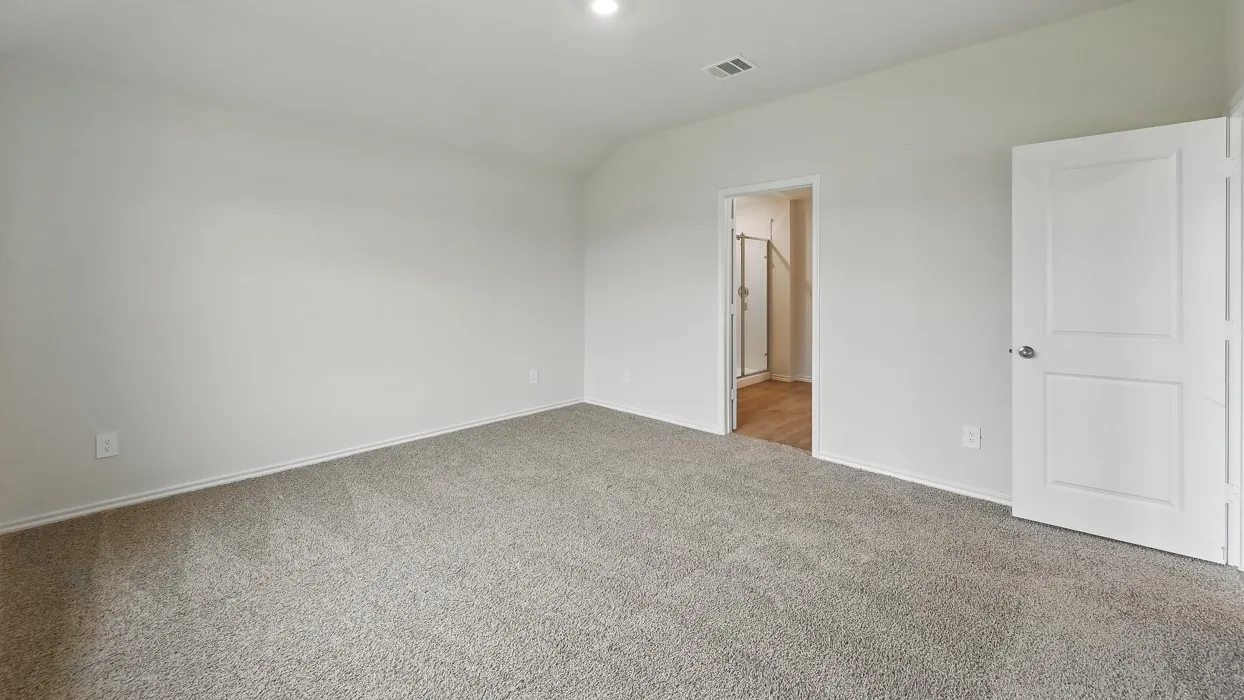 Neutral-toned carpeting, recessed ceiling lighting, and a white interior door