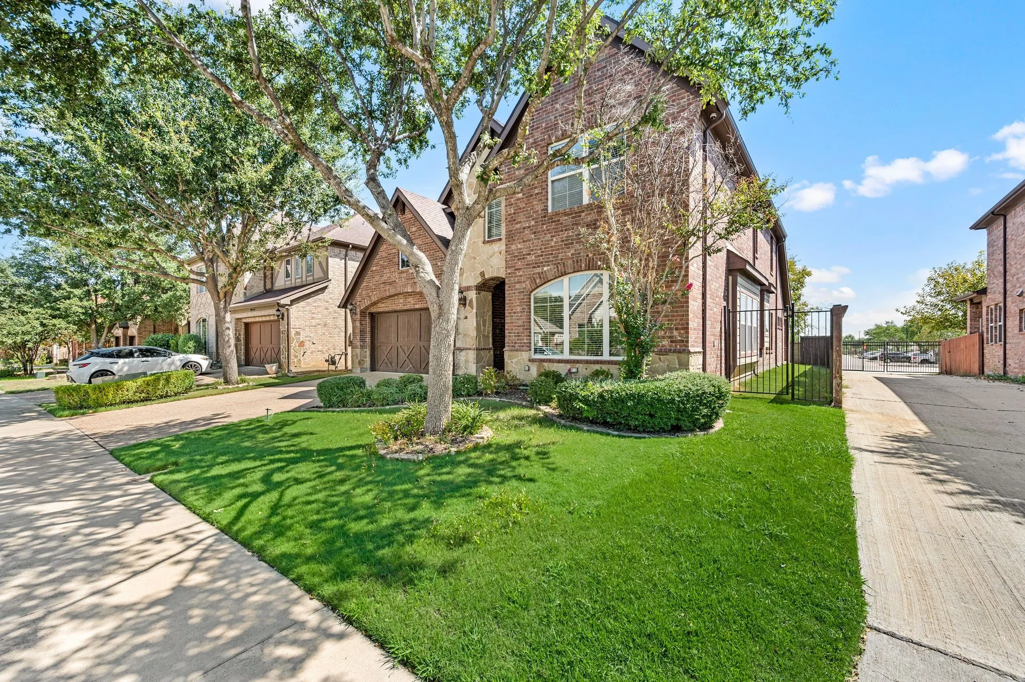 Brick exterior with stone accents, arched entry, arched windows, and an attached garage with a wood-finish door