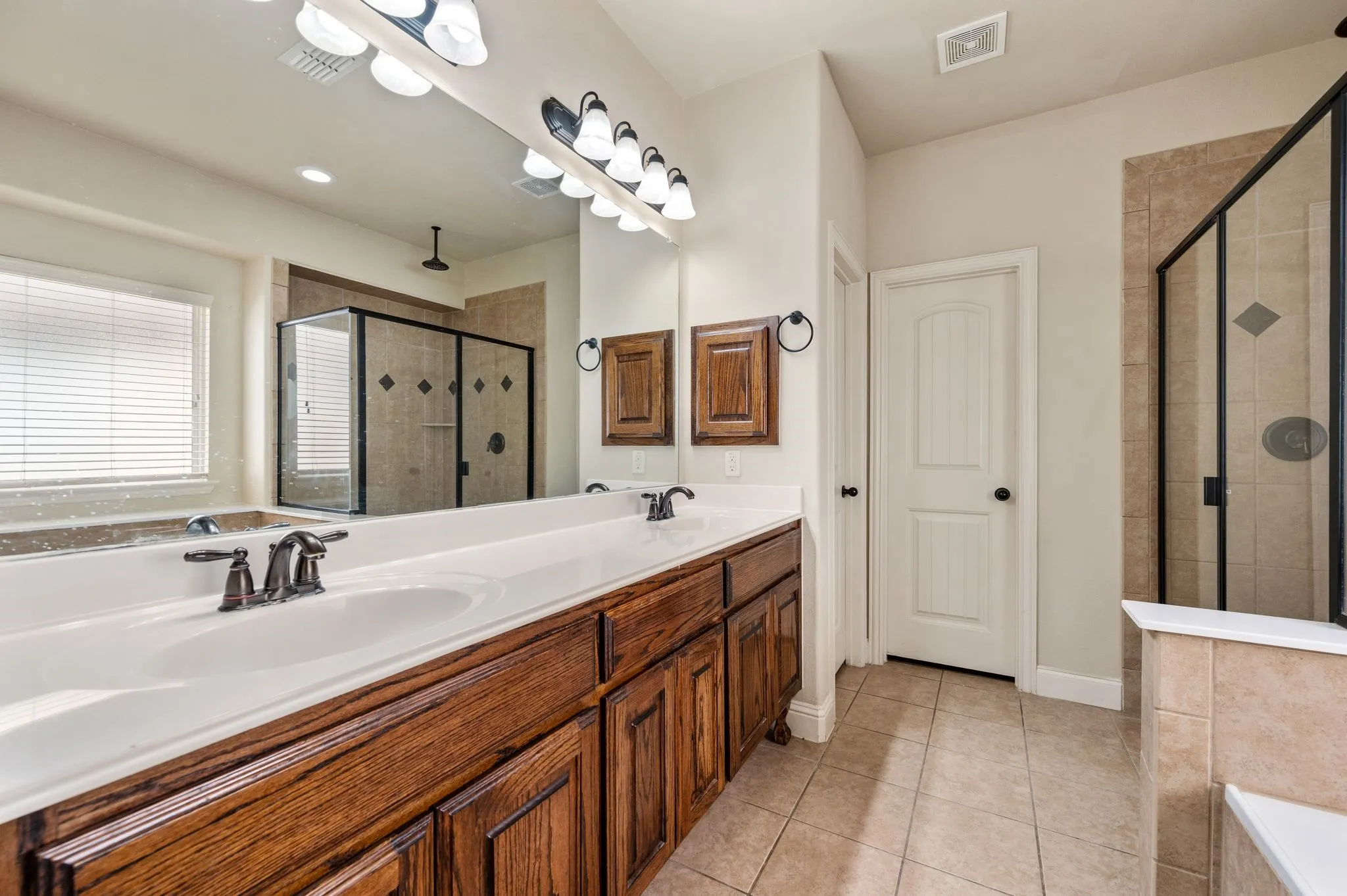 Double vanity with wood-finish cabinetry and integrated sinks