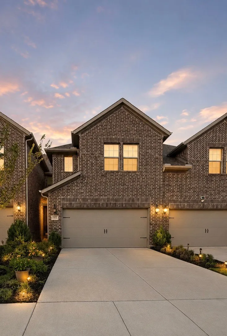 Brick facade with gabled roofline, two-car garage, and concrete driveway