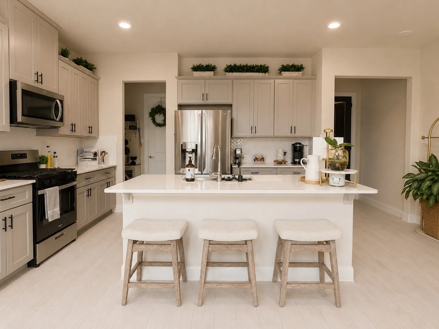 Gourmet kitchen featuring a center island with countertop seating, stainless steel appliances, light wood-finish flooring, and shaker-style cabinetry